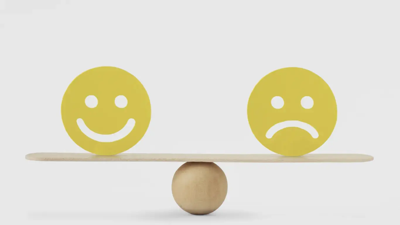 Happy & Sad Emotion balanced on a see-saw.