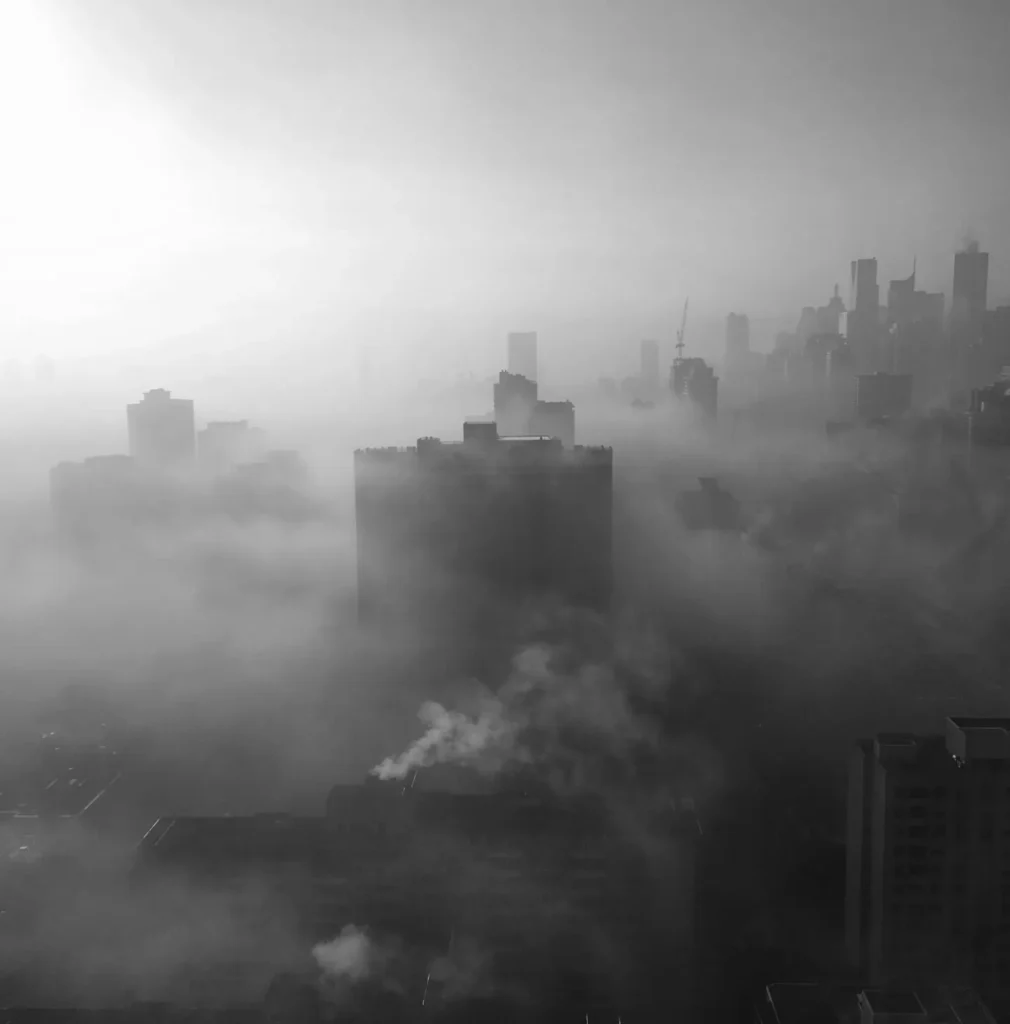 A black and white image of city showing smog and air pollution.