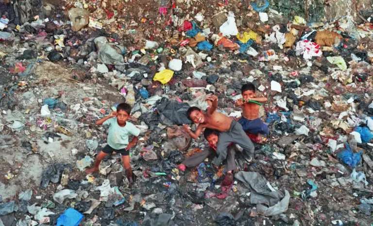 Small children playing in unhygienic waste yard in search or in search of food.