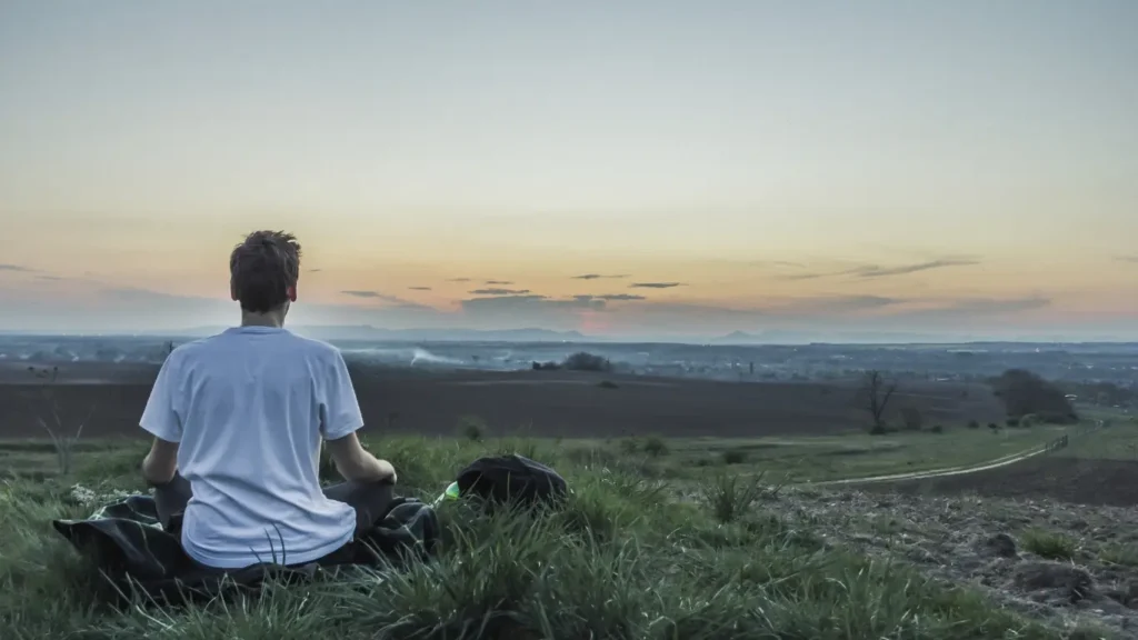 Young man meditates peacefully in nature.